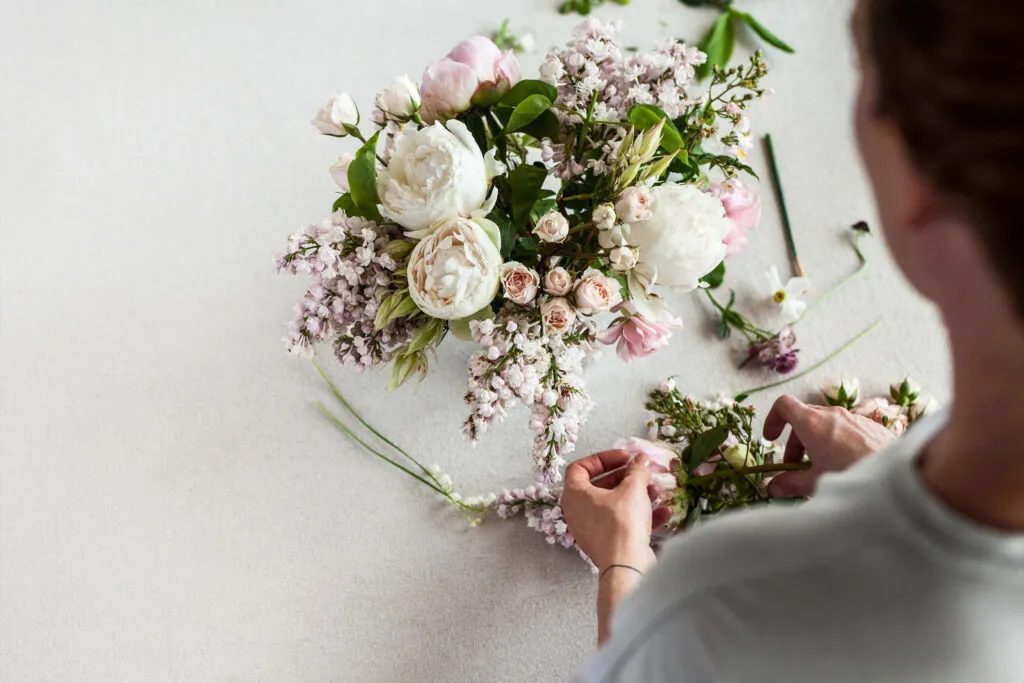 Woman arranging flowers at Petal & Pine Florist Studio