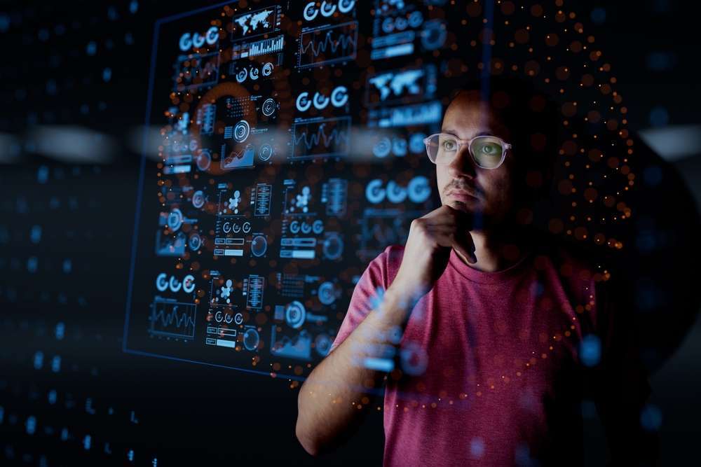Man analyzing digital marketing data metrics on a screen, reflecting the importance of initial channel measurements for strategic marketing decisions.