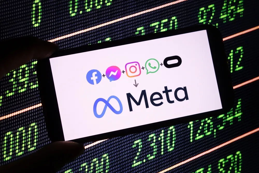 Smartphone displaying Meta logo and social media icons (Facebook, Instagram, WhatsApp) against digital stock market background, representing B2B advertising potential on Meta platforms.